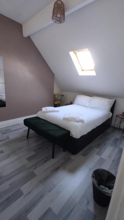 a bedroom with a large bed with a skylight at Flat 2, Close to all amenities Shared bathroom in Cardiff