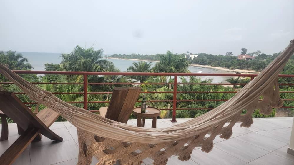 a hammock on a balcony with a view of the water at BEACHFRONT APPARTMENT in Kribi