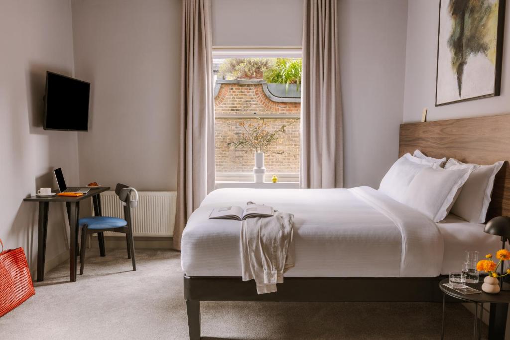 a hotel room with a bed and a window at Sonder The Gilbert in London