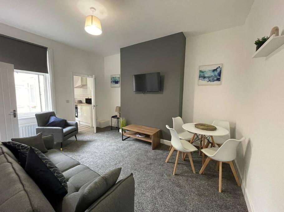 un soggiorno con divano e tavolo di Coastal Tyneside Flat a Westoe