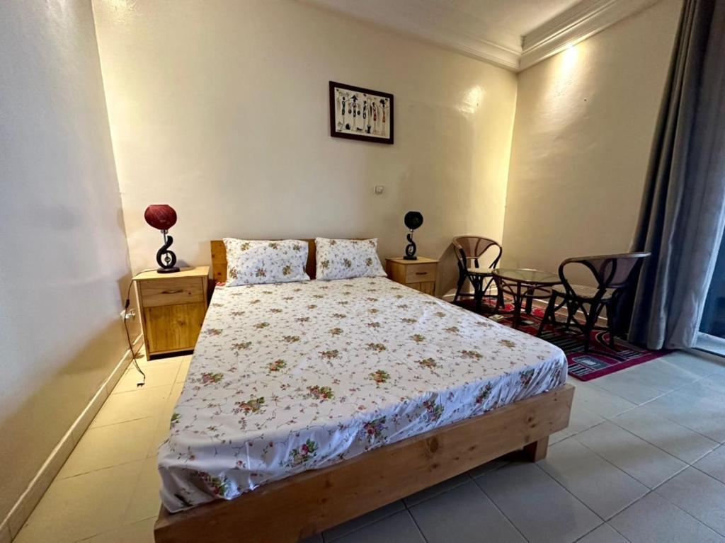 1 dormitorio con 1 cama, mesa y sillas en Studio Le Virage, en Dakar