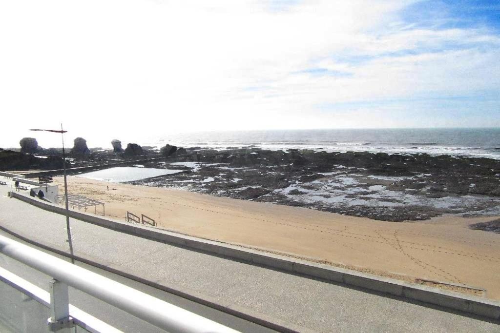 une route à côté d'une plage avec l'océan dans l'établissement Le face mer de la Corniche Vendéenne, à Saint-Hilaire-de-Riez