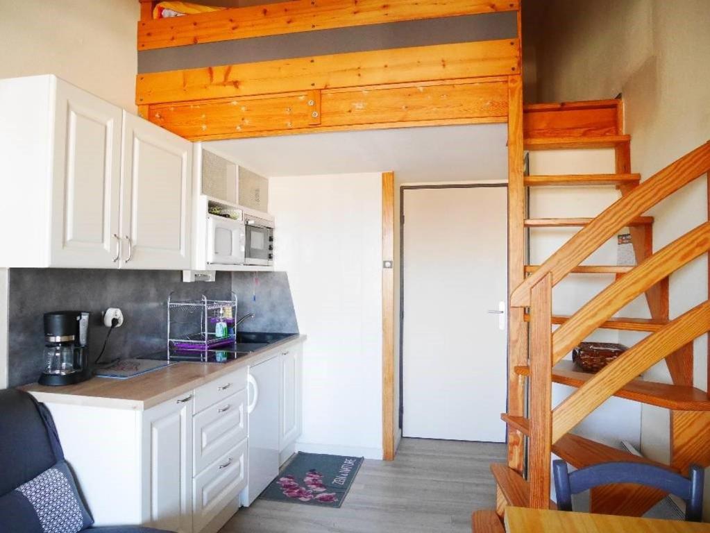 - une cuisine avec une mezzanine dans une petite maison dans l'établissement Le studio de la corniche, à Saint-Hilaire-de-Riez