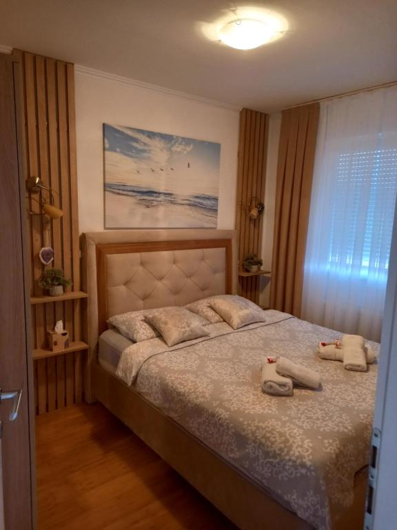 - une chambre avec un lit avec deux animaux rembourrés dans l'établissement Apartman Jana, à Doboj