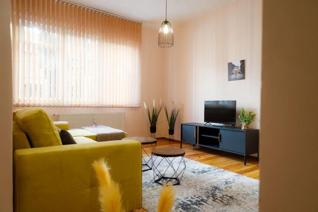 a living room with a yellow couch and a television at A gem in the heart of Sofia 1BDR str Slavyanska in Sofia