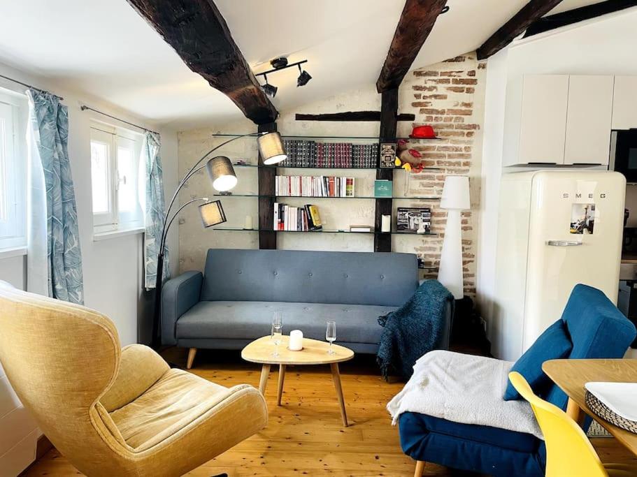 un salon avec un canapé bleu et une table dans l'établissement Le Chaîne - Vieux port centre, à La Rochelle