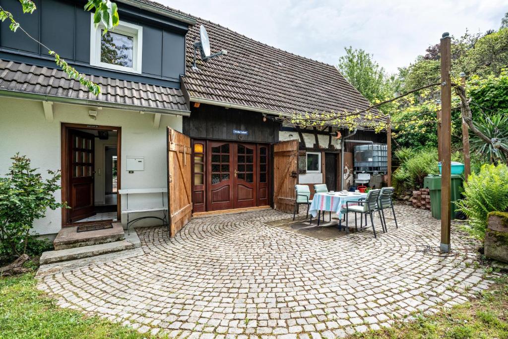 a patio with a table and chairs in front of a house at Ferienhaus S' Äckerle in Lauf
