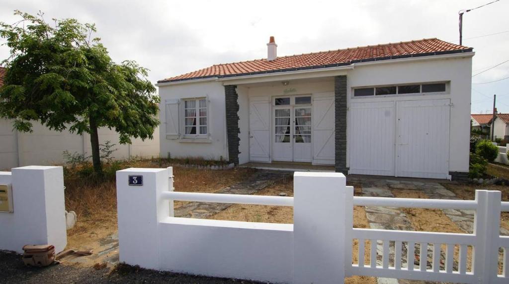 une clôture blanche devant une maison blanche dans l'établissement La tranquille de St Hilaire, à Saint-Hilaire-de-Riez