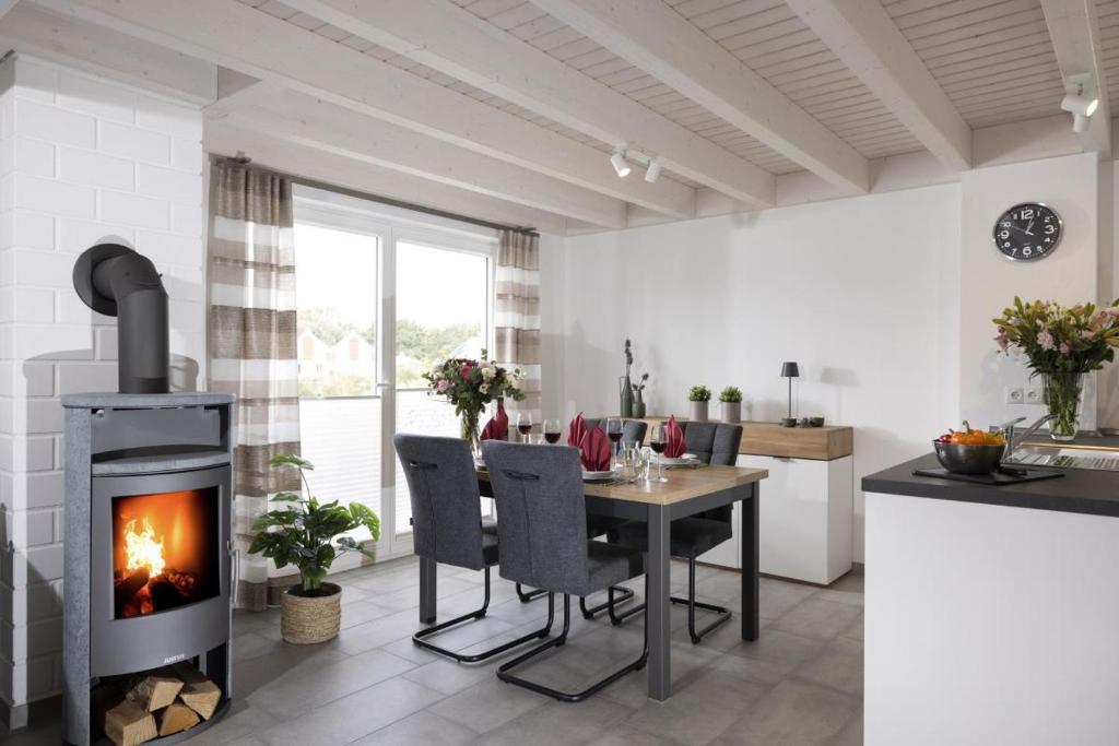 a kitchen and dining room with a fireplace at Haus Norwald - tolles Ferienhaus direkt am See für bis zu 4 Personen mit Sauna und Kaminofen - Haustiere herzlich willkommen in Nordhorn