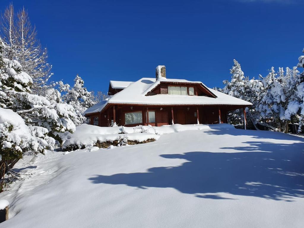 a house covered in snow in front at Casa Rincón Radales in San Martín de los Andes