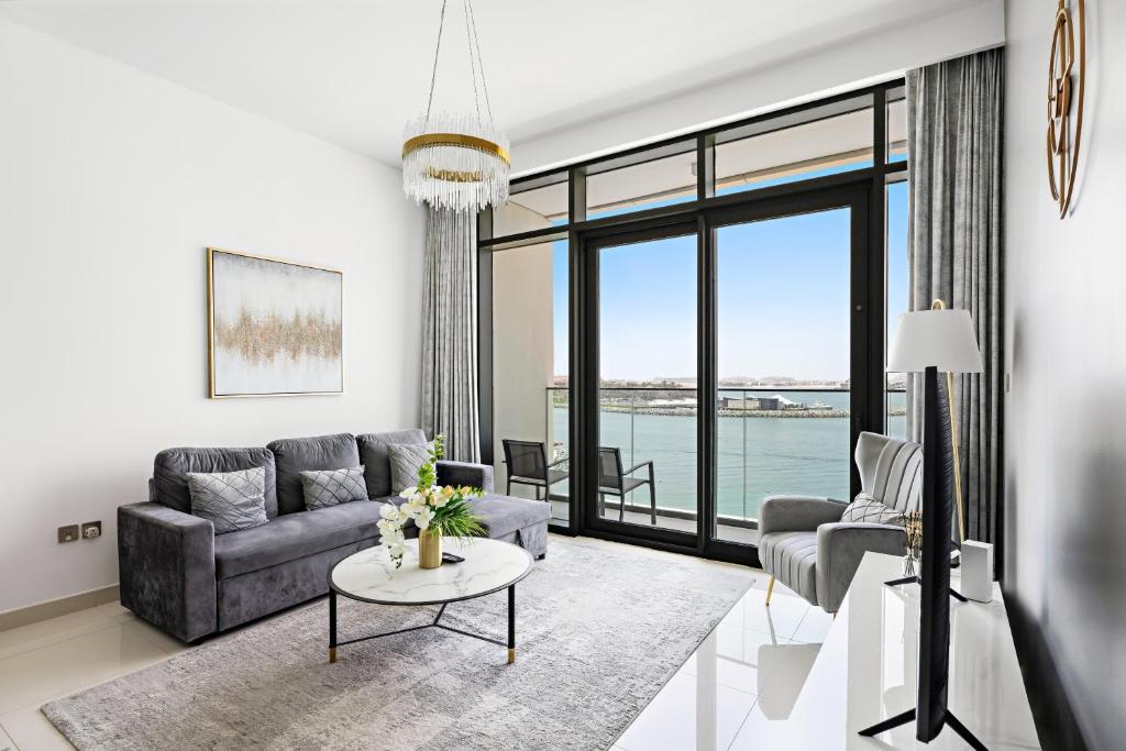 una sala de estar con un sofá y una mesa en Seaside Serenity: 1-BR Apartment with Beach Access, en Dubái