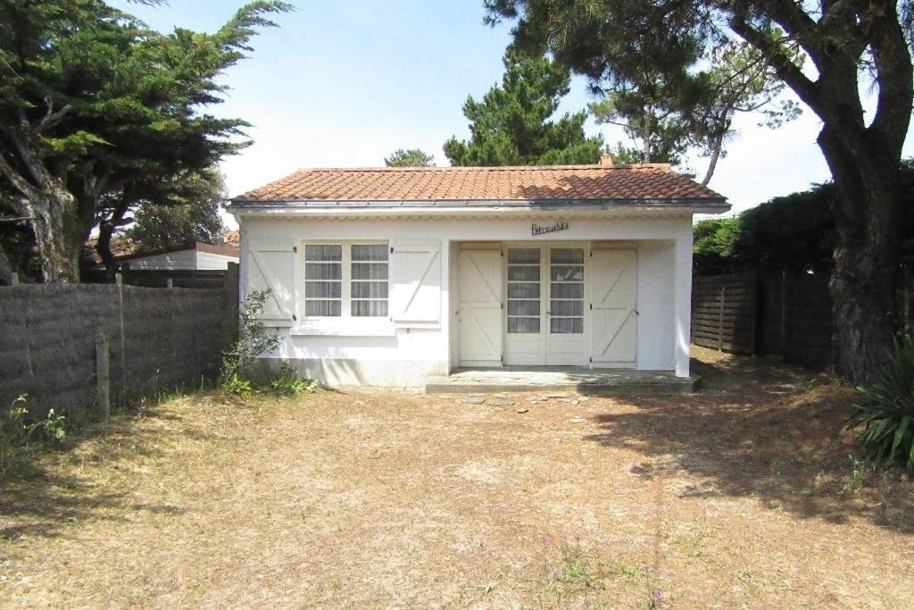 ein weißes Haus mit einem Zaun davor in der Unterkunft Pétrouchka dans les pins in Saint-Hilaire-de-Riez