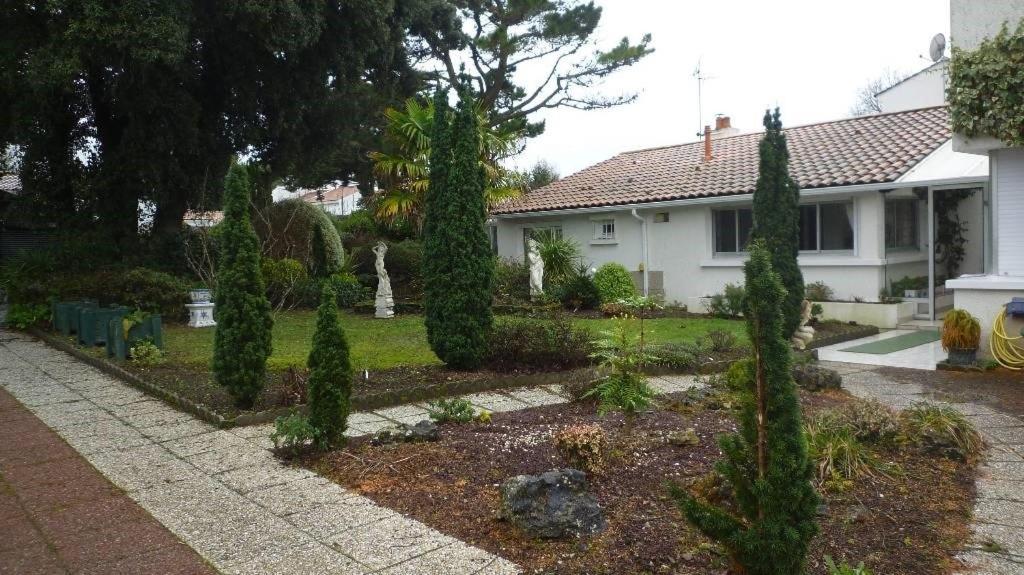 une maison avec un jardin planté d'arbres et de buissons dans l'établissement La Villa de la foret, à Saint-Hilaire-de-Riez