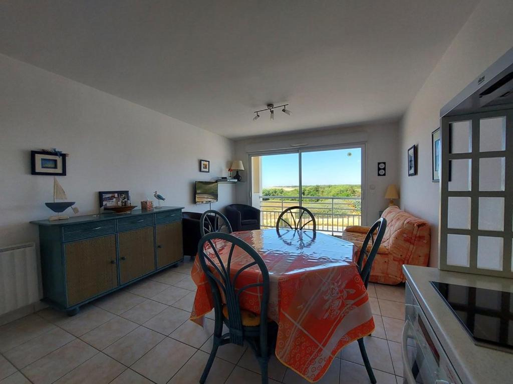 a kitchen and dining room with a table and chairs at La baie de Sion in Saint-Hilaire-de-Riez
