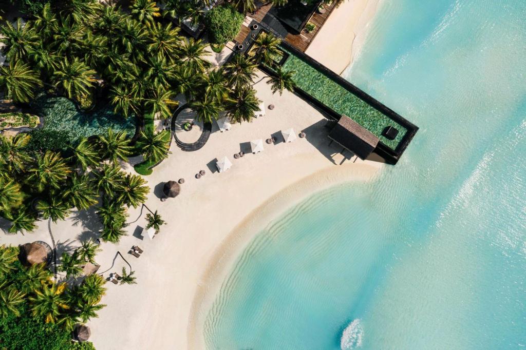 an aerial view of a beach with umbrellas at One&Only Reethi Rah in Reethi Rah