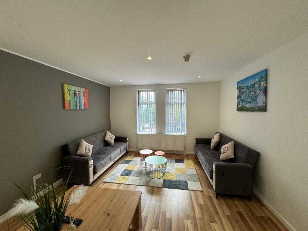 uma sala de estar com dois sofás e uma mesa de centro em MK Apartments, City of Manchester, Chorlton em Manchester