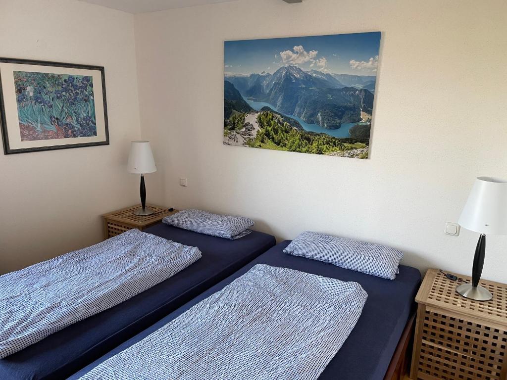 - 2 lits dans une chambre avec une photo sur le mur dans l'établissement Meridiana 2, à Tuntenhausen