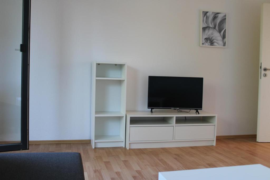 a living room with a television on a white entertainment center at Zweites Zuhause in Recklinghausen
