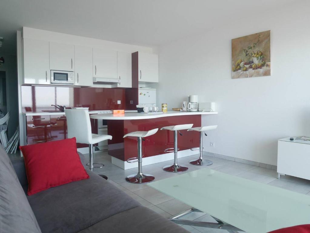 ein Wohnzimmer mit Sofa und eine Küche in der Unterkunft L'estivant sur l'océan in Saint-Hilaire-de-Riez