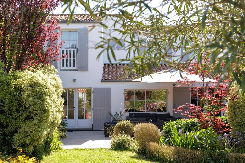 une maison blanche avec un jardin en face dans l'établissement La Martinoise Garden, à Saint-Martin-de-Ré