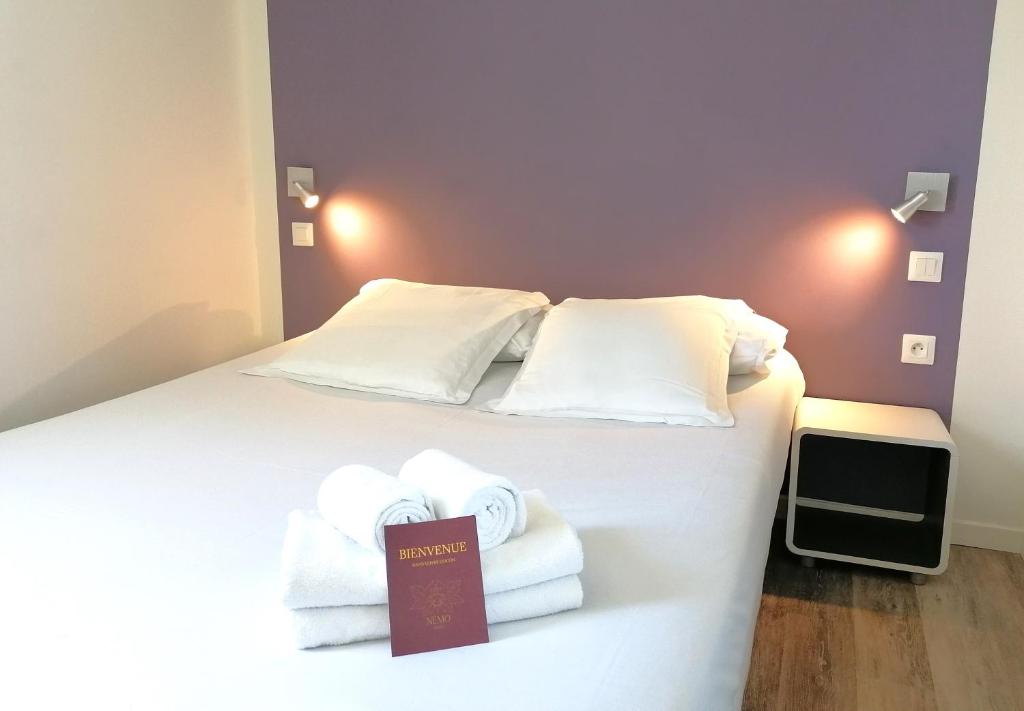 Una habitación de hotel con una cama con toallas. en Hôtel Némo Aéroport de Pau - KB HOTEL GROUP en Sauvagnon