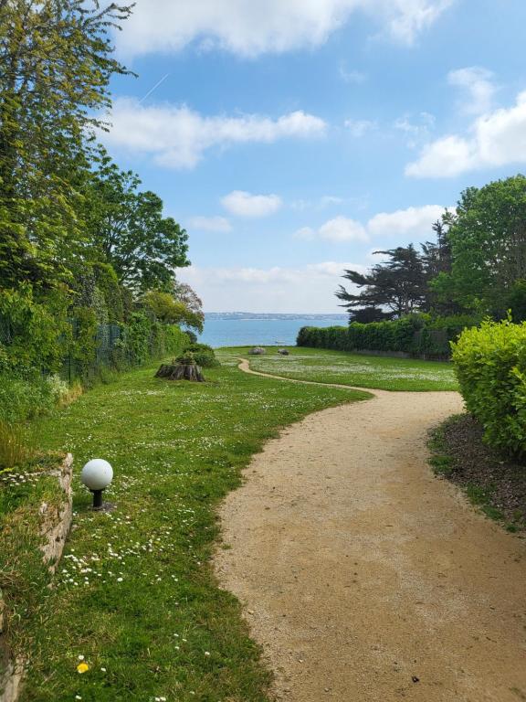 un chemin de terre menant à l'océan par beau temps dans l'établissement LE BLEU HORIZON, à Fouesnant
