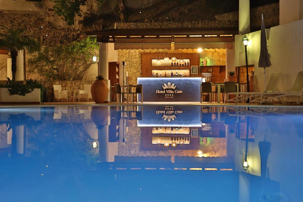 a swimming pool with a bar in the background at Hotel Villa Cute - HVC in Lipari