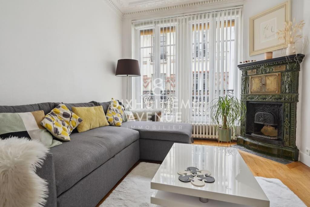 un salon avec un canapé et une cheminée dans l'établissement Modernité et confort à Montmartre, à Paris