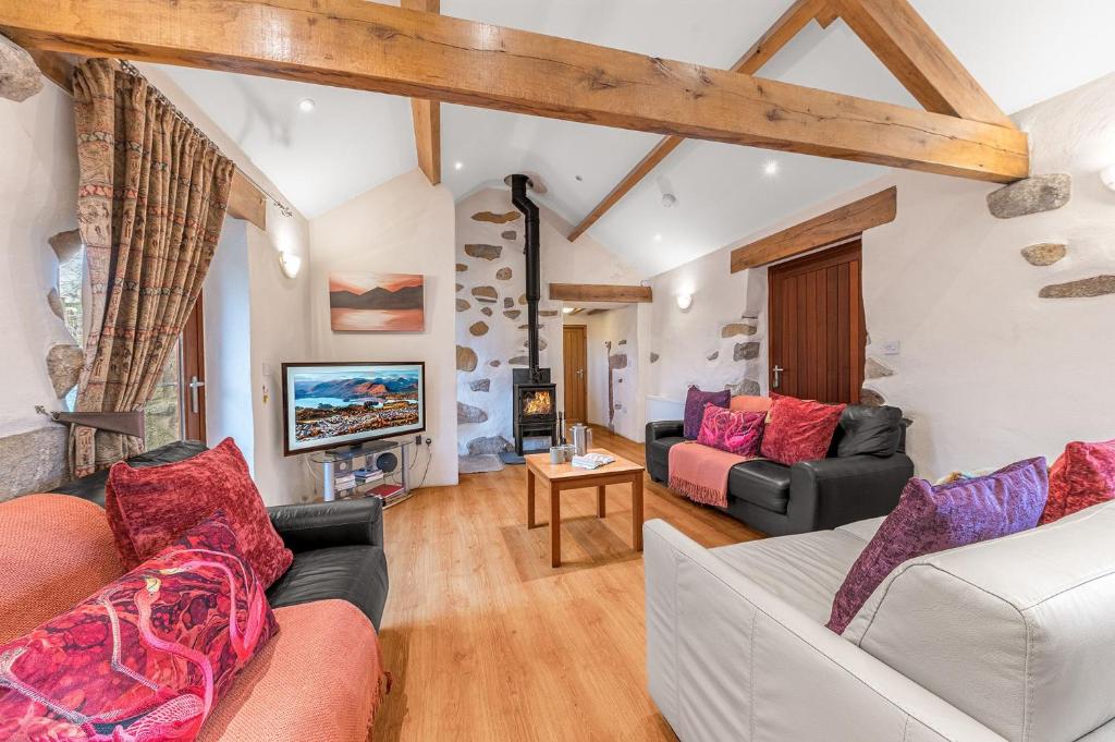 a living room with two couches and a tv at Damson Cottage in Waberthwaite