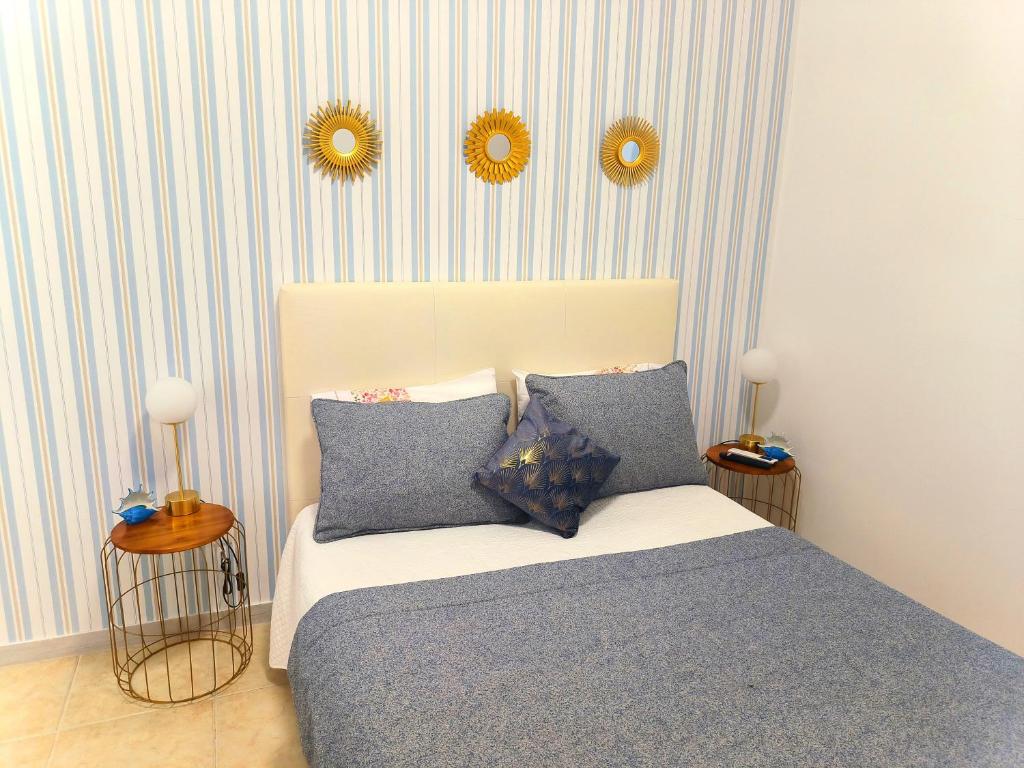 um quarto com uma cama e dois espelhos na parede em MAR ROSA, estacionamento gratuito na Nazaré