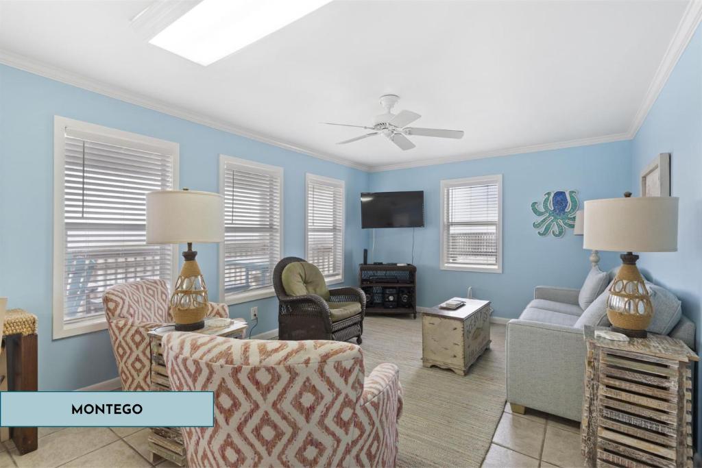 uma sala de estar com paredes azuis e um sofá e cadeiras em Gulf Front Beach House Sleeps 12 em Gulf Shores