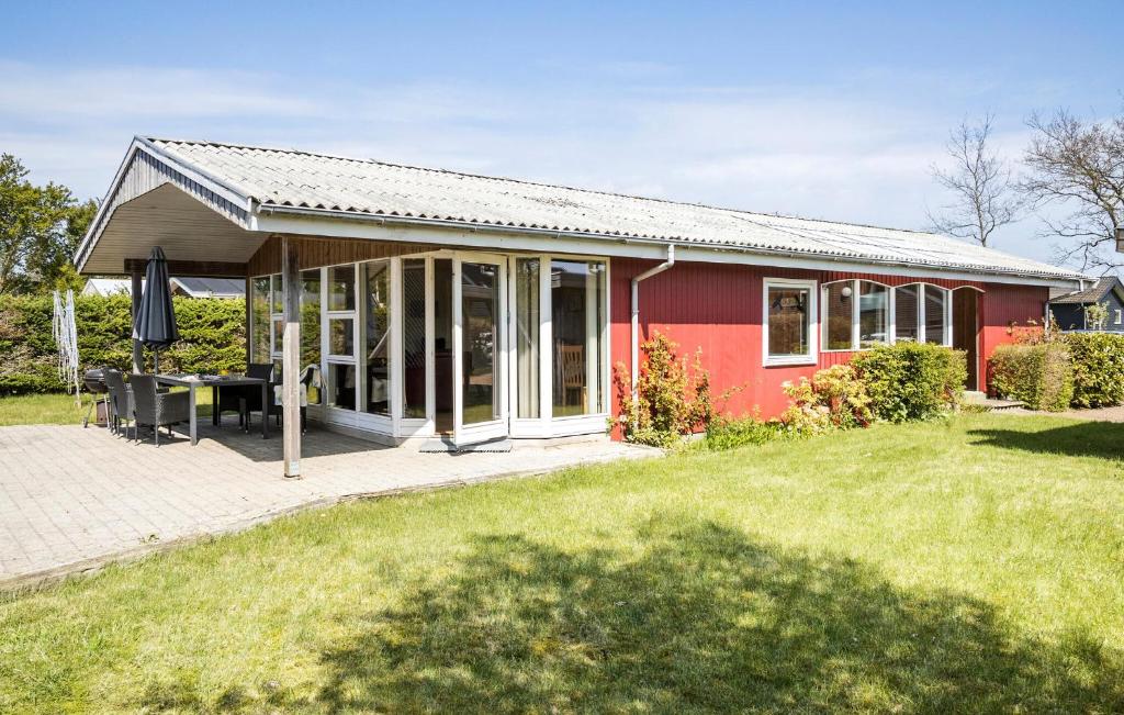 a red house with a patio in a yard at Beautiful Home In Middelfart With Wifi in Middelfart