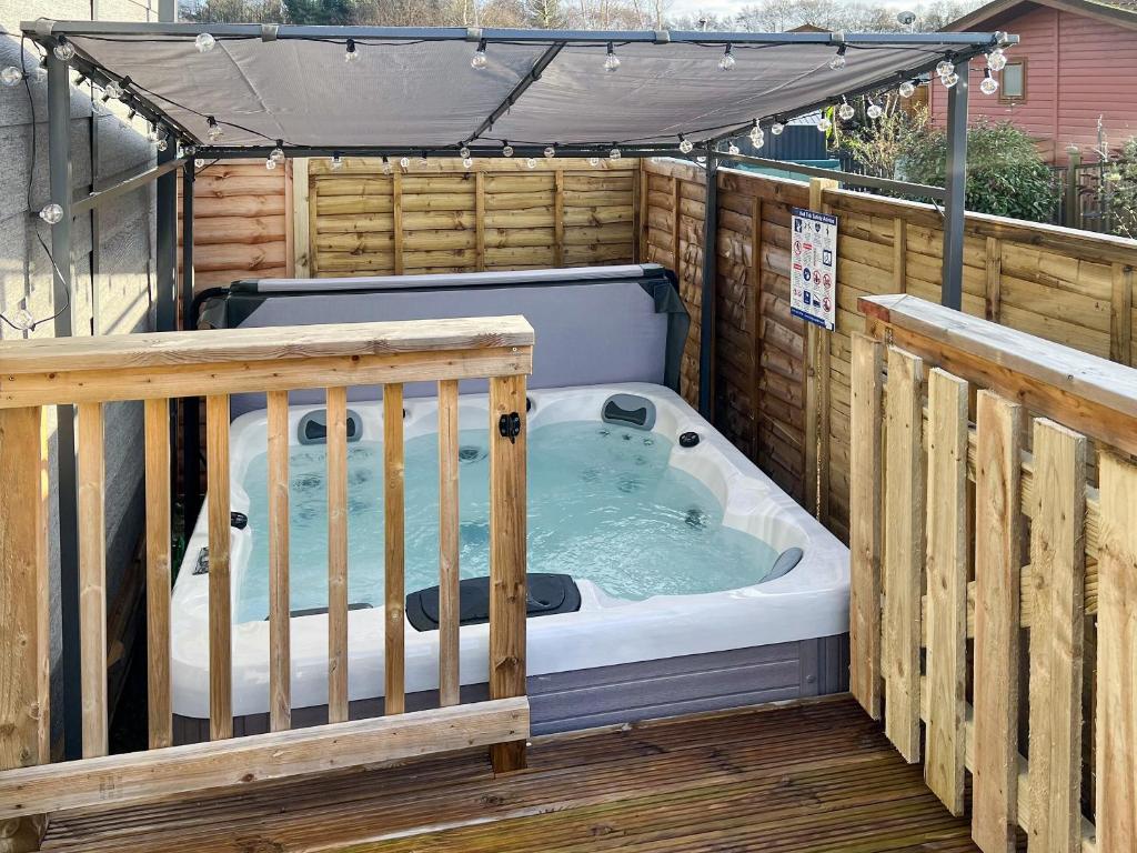 a hot tub on a deck with a gazebo at Harwood Lodge in Wilberfoss
