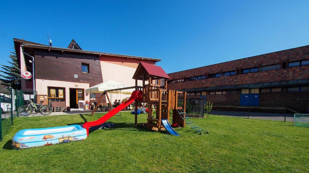 un parco giochi con scivolo sull'erba di fronte a un edificio di Penzión Squash a Liptovský Mikuláš