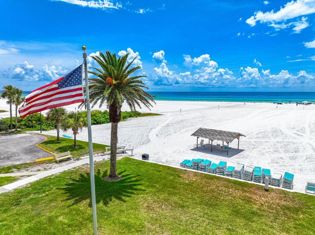 an aerial view of a beach with chairs and a flag at Jamaica Royale Beachfront Tower in Siesta Key