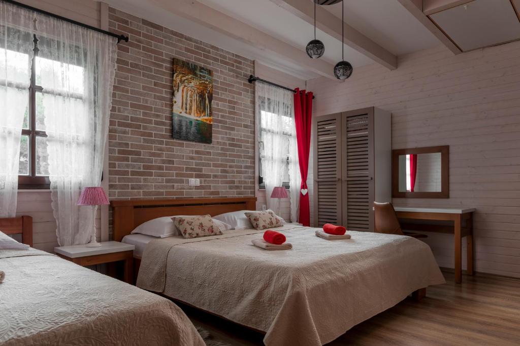 a bedroom with two beds and a brick wall at Apartmani Ivanka in Rakovica