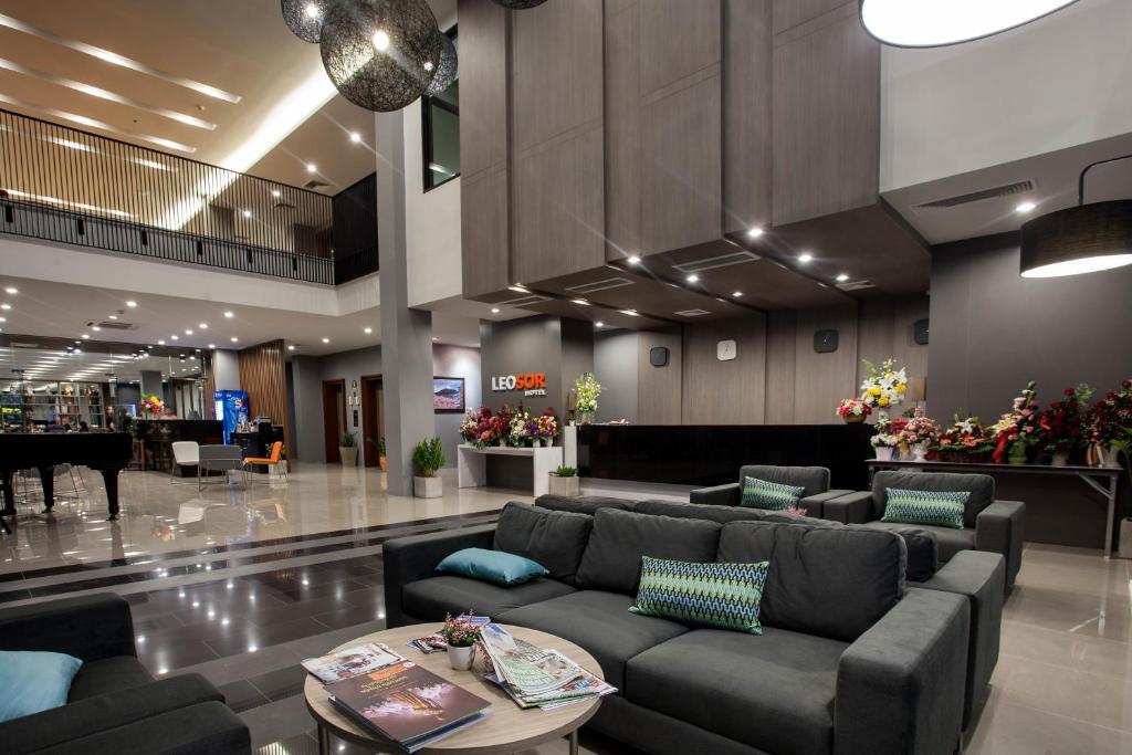 vestíbulo con sofá y mesa en Leosor Hotel en Nakhon Ratchasima