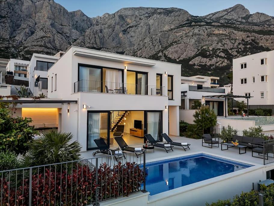 a house with a swimming pool in front of a mountain at Ferienhaus Komplex - Villa Oliver - Makarska Exklusiv in Veliko Brdo