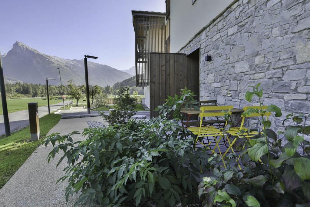 a stone building with a yellow table and chairs at Appartement Samoens l'Etelley in Samoëns