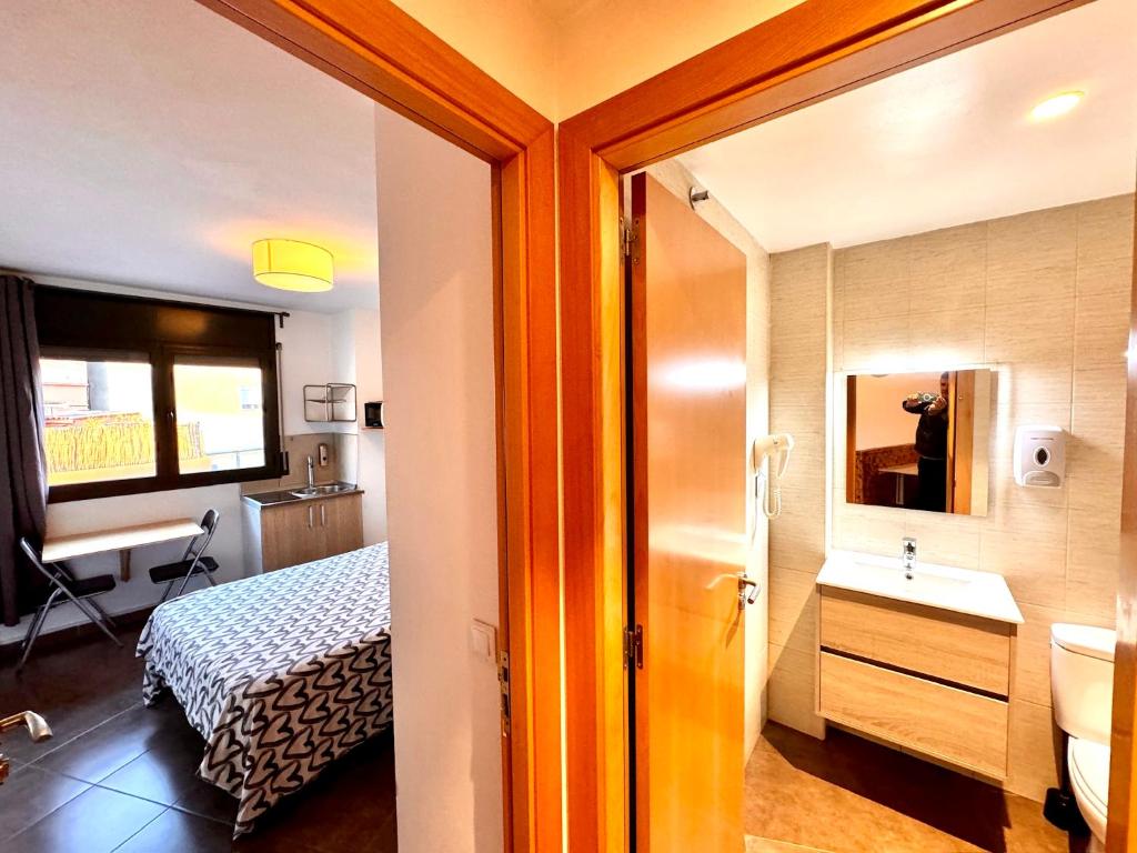 a room with a bathroom with a bed and a sink at MT Nuevos Apartamentos y Suites con baño privado in Mataró