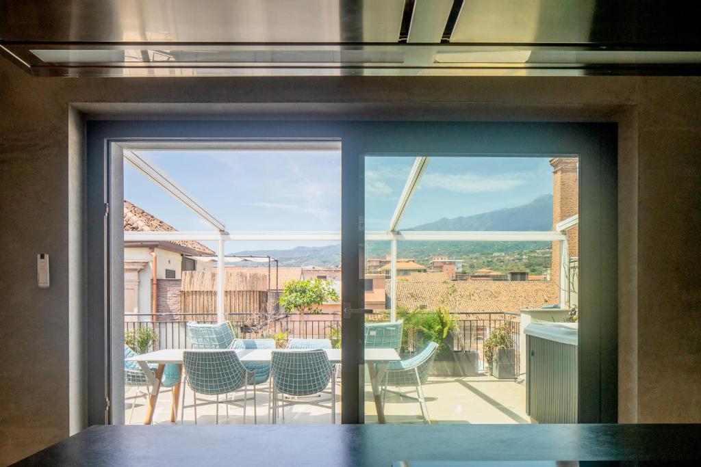 a glass door leading to a patio with a table and chairs at Casa Rebecca in Riposto