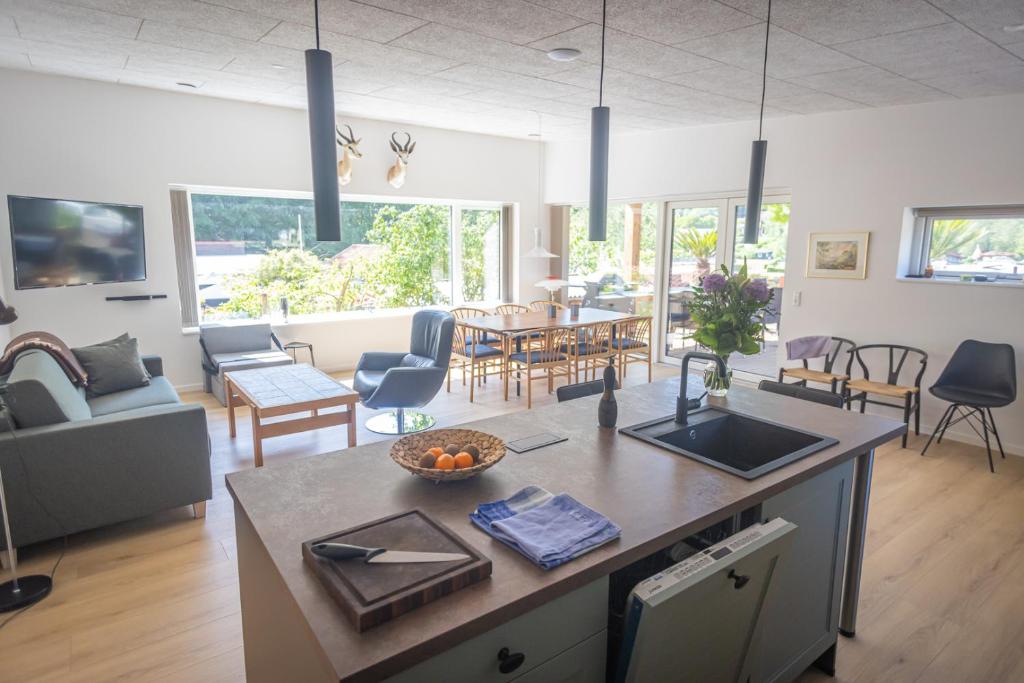 een keuken en een woonkamer met een tafel en stoelen bij Randbøldal Camping & Cabins in Randbøl