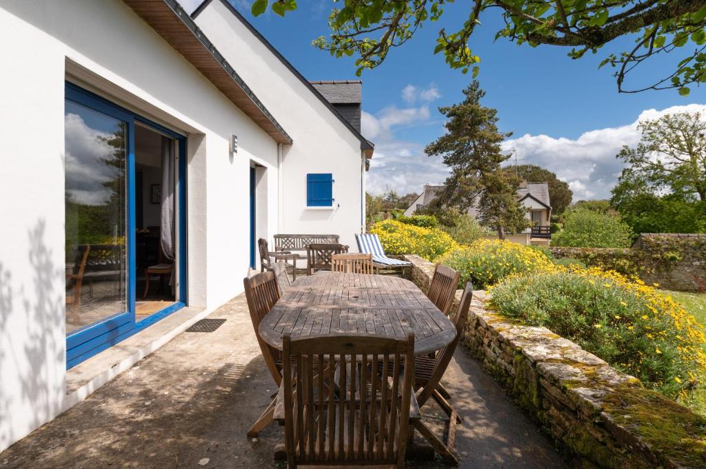 a table and chairs on the patio of a house at La maison aux volets bleus in Arzon