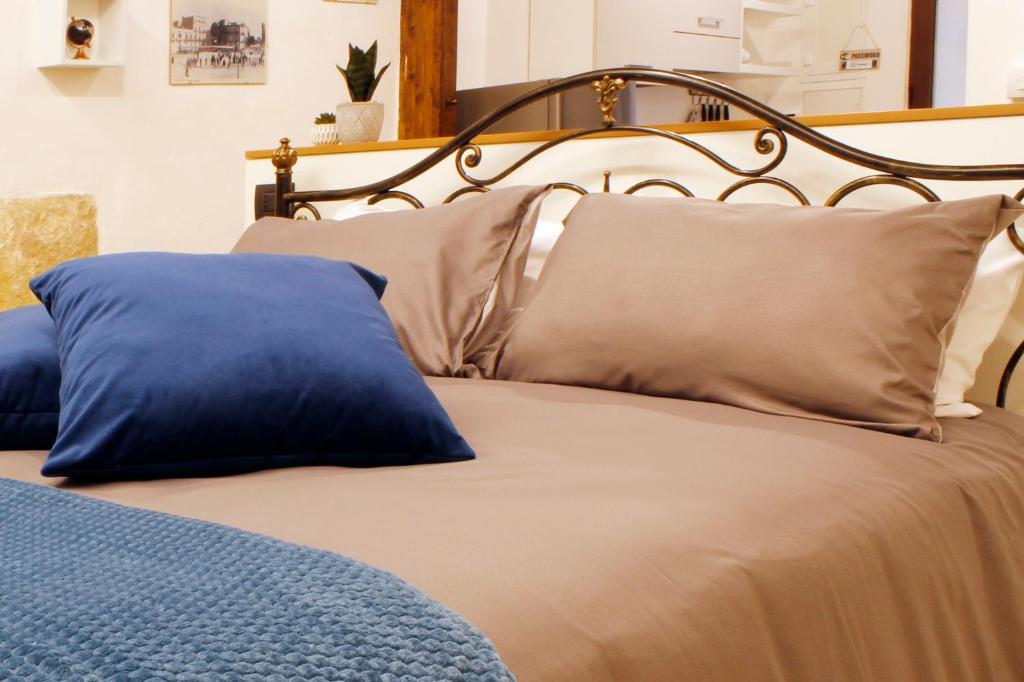 a bed with blue and tan pillows and aintendent at La perla casa vacanze in Barletta