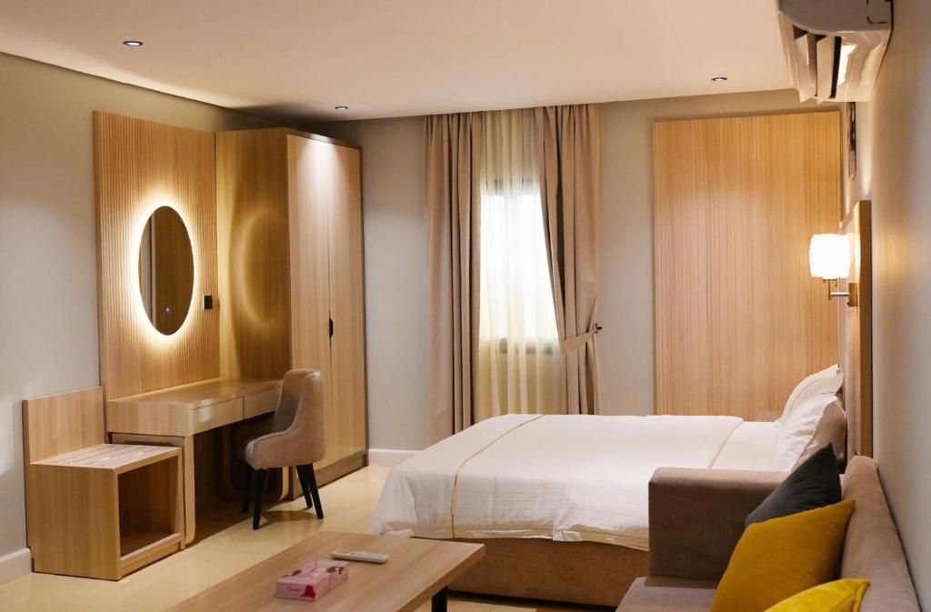 a hotel room with a bed and a desk at Blend Hotel in Dammam