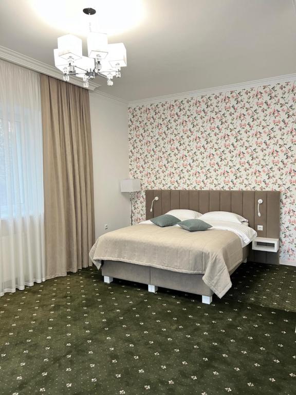 a bedroom with a bed and a floral wall at Vik-Jan in Khmelnytskyi