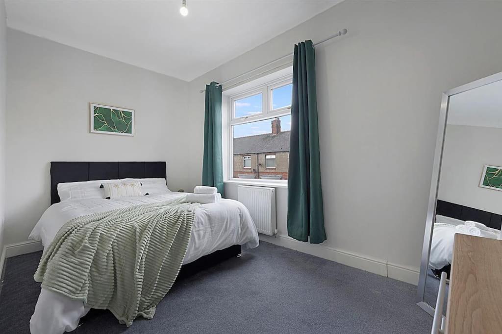 um quarto com uma cama grande e uma janela em Frances Terrace Haven em Bishop Auckland