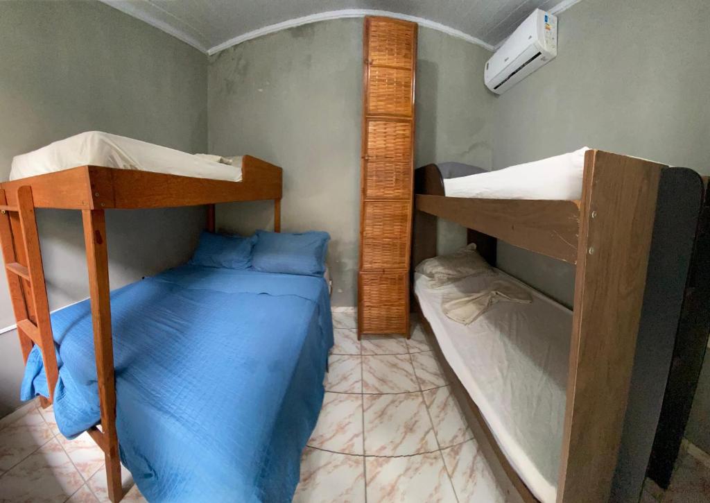 a bedroom with two bunk beds and a blue bed at Hostel Sol da Barra in Salvador