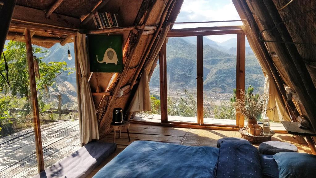 a living room with a couch and a large window at Imani Eco Sky Lodge Ngoc Chien in Nam San