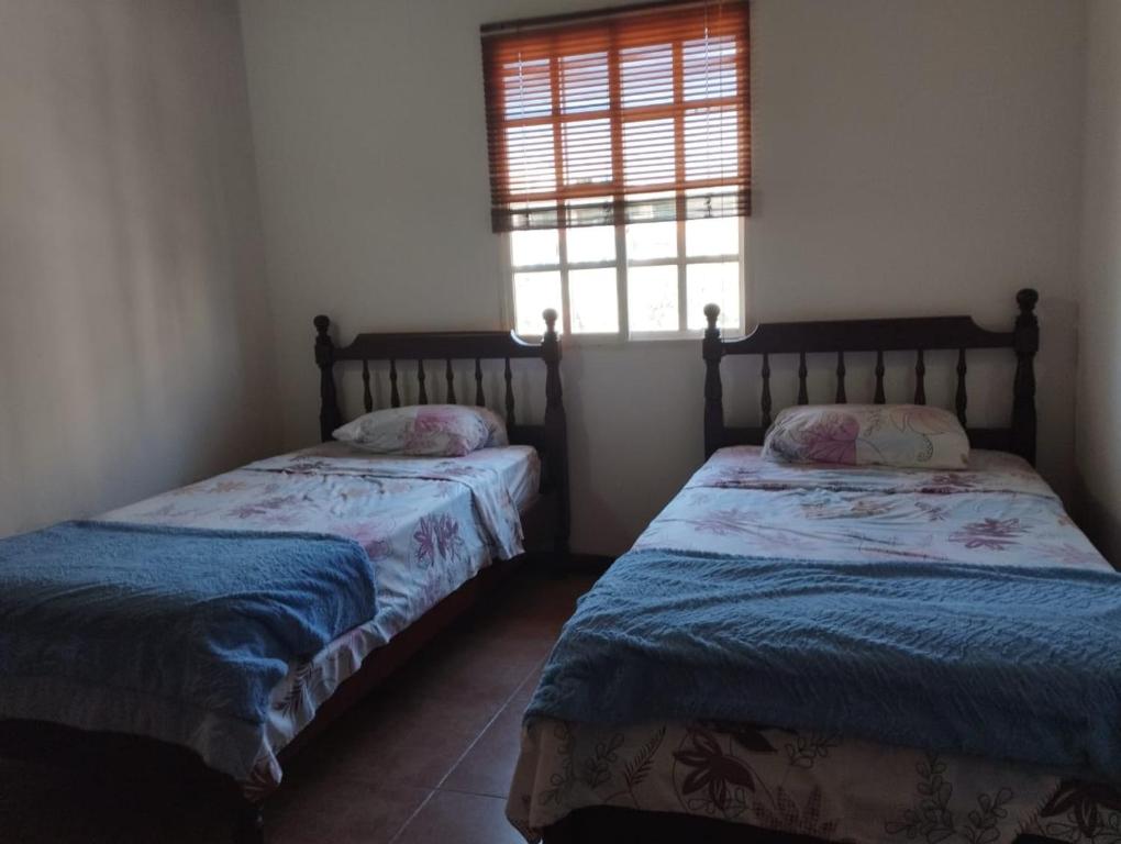 two beds sitting in a room with a window at Villa Martinica in El Morro de Barcelona